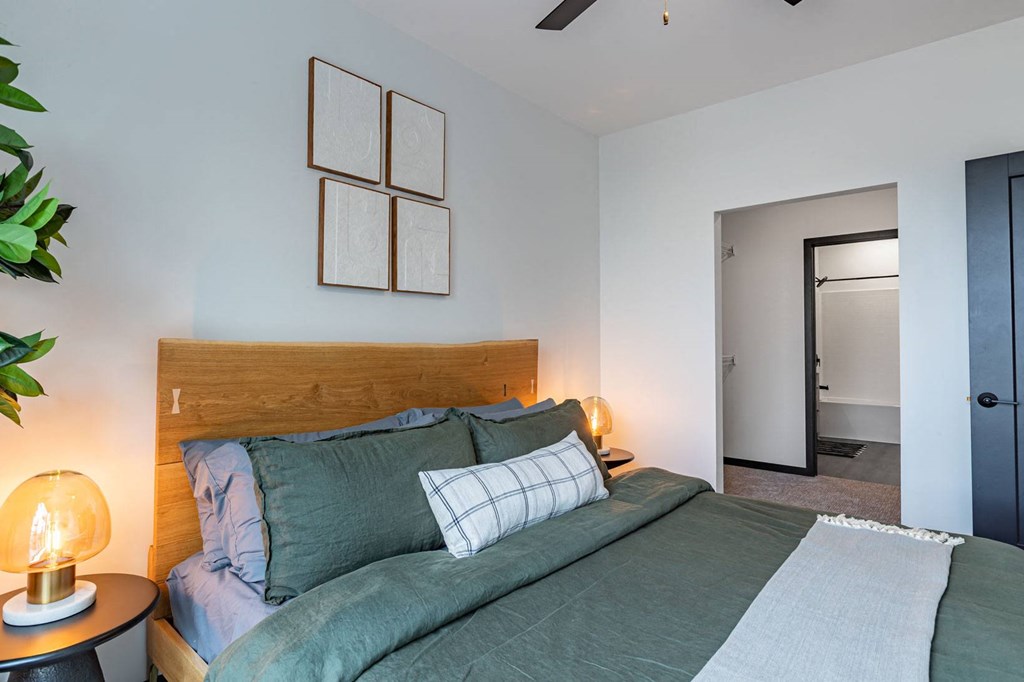 a bedroom with a bed and some pictures on the wall