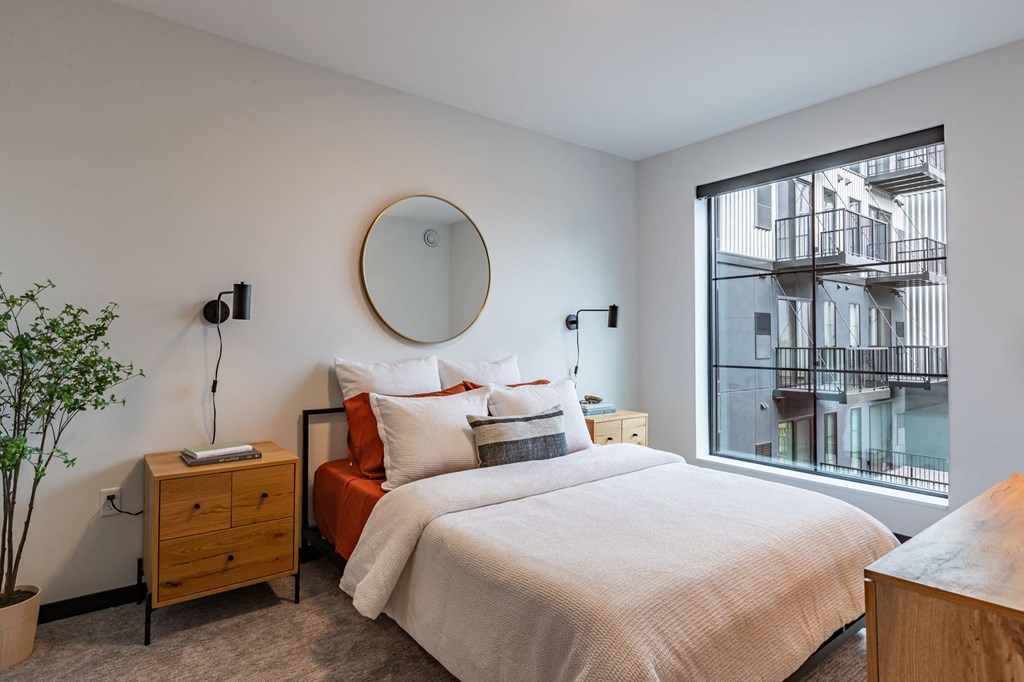 a bedroom with a bed and a large window