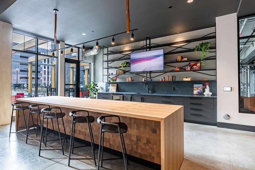 a large wooden table in a restaurant with bar stools