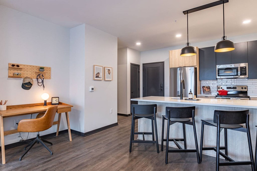 a kitchen and dining area with a bar and stools