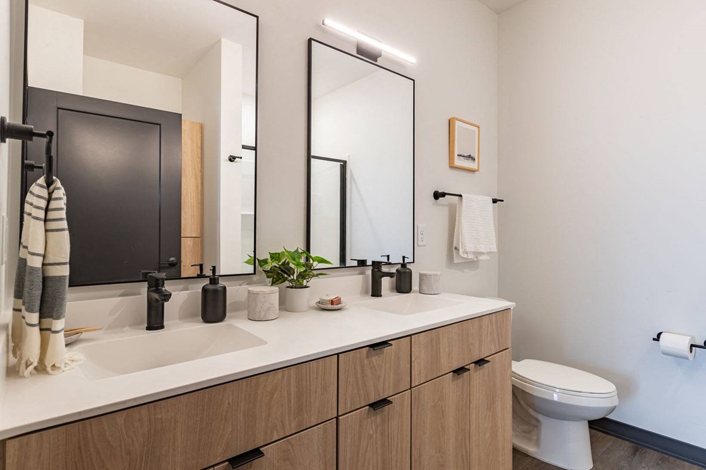 a bathroom with two mirrors and a sink and a toilet
