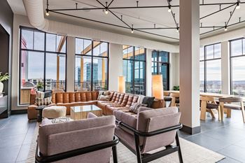 a lounge area with couches and chairs and a view of the city