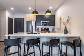 a kitchen with a counter and three stools