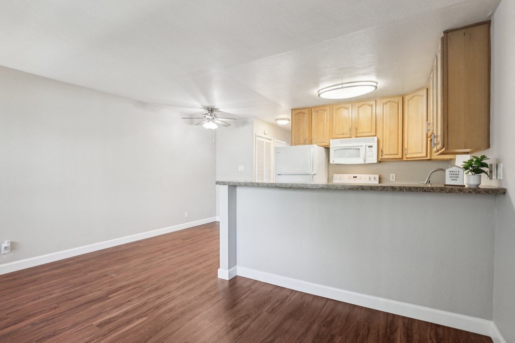 Townhomes for Rent in Walnut Creek, CA - Carmel House - Kitchen with Wood-Inspired Flooring, High Countertop, White Appliances, and Wood-Tone Cabinets.