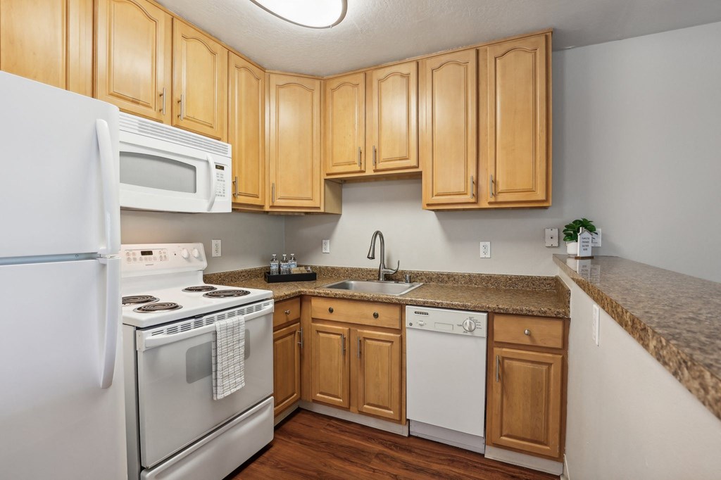 a kitchen with white appliances and wooden cabinets