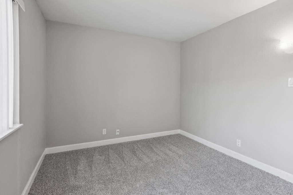 an empty room with carpet and a window