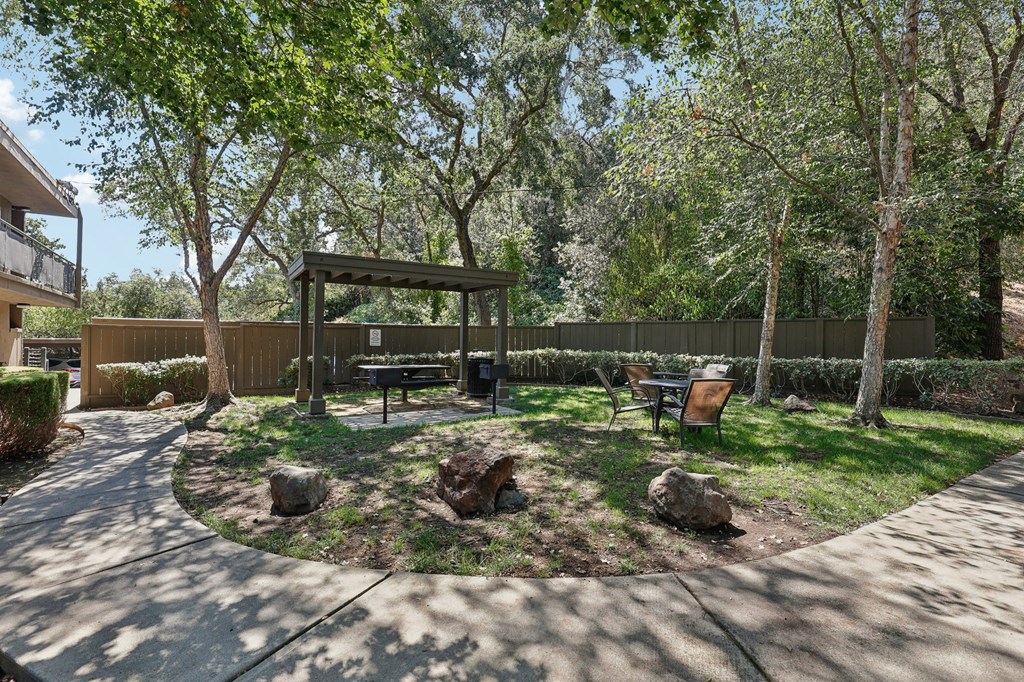 a backyard with a picnic table and a bench
