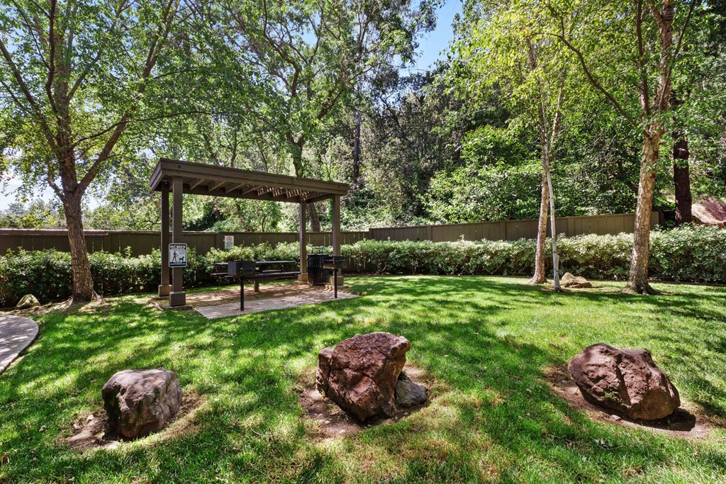 a backyard with a picnic area and rocks