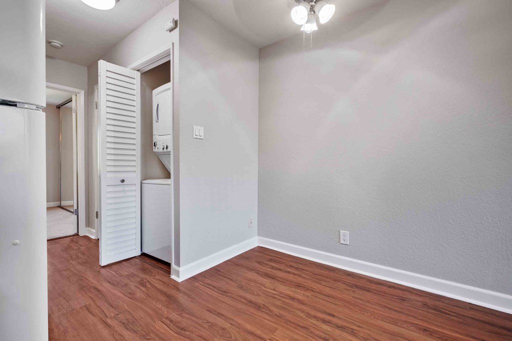 an empty living room with wood flooring and a white closet