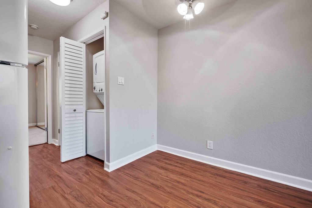 an empty living room with wood flooring and a white closet
