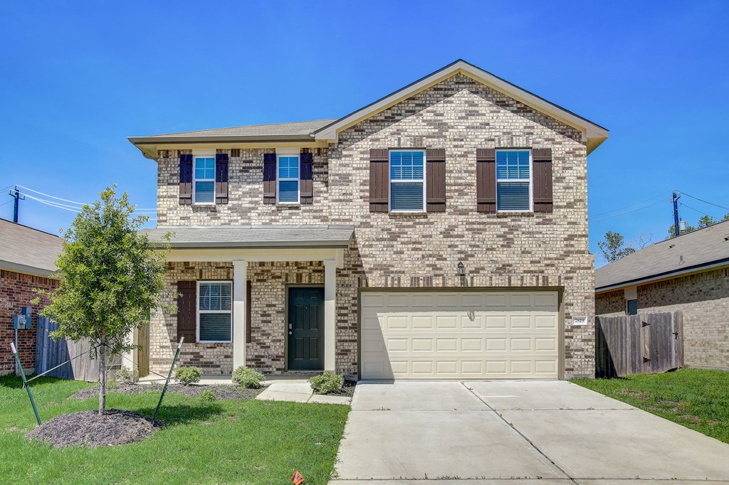 a tan brick house with a white garage door