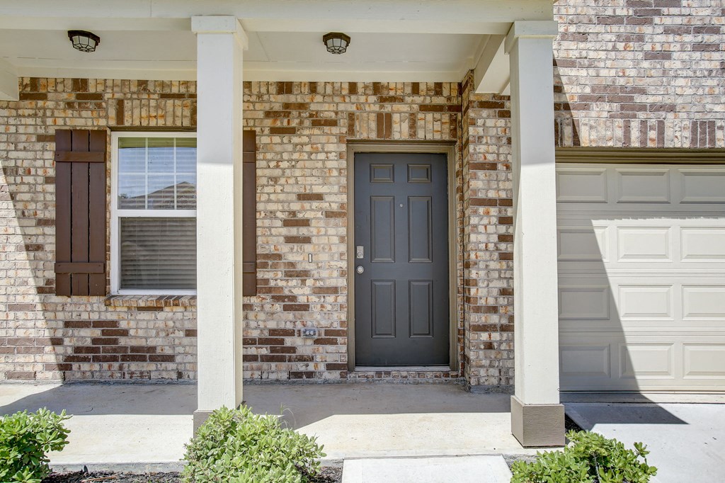 the front door of a brick house with a black door