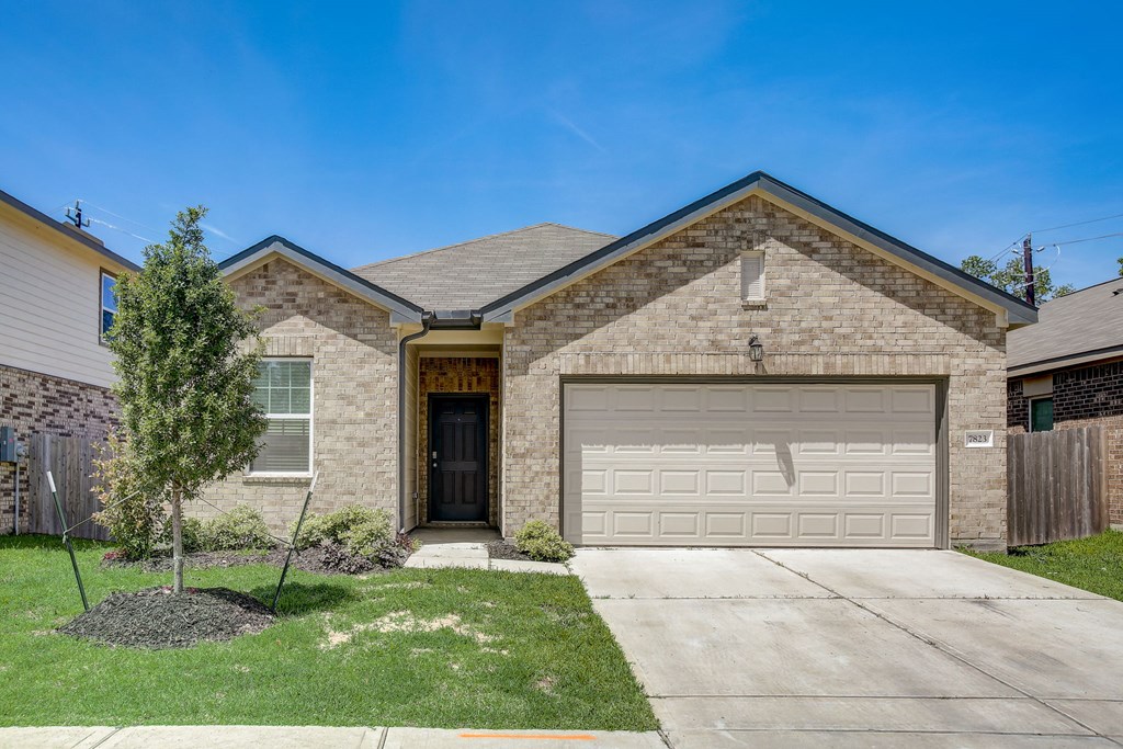 a tan brick house with a white garage door