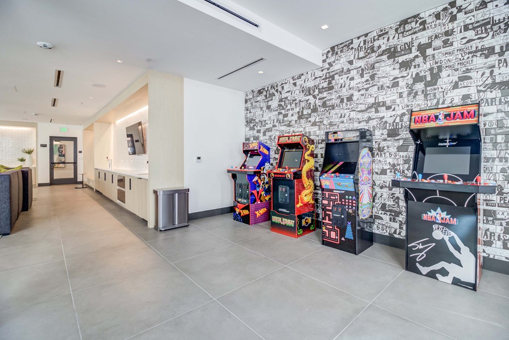 the lobby of a building with video game machines and a white wall