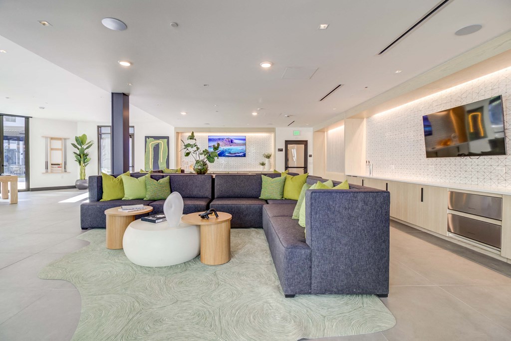 a living room with blue couches and green pillows