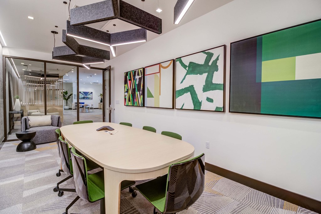 a conference room with a round table and green chairs