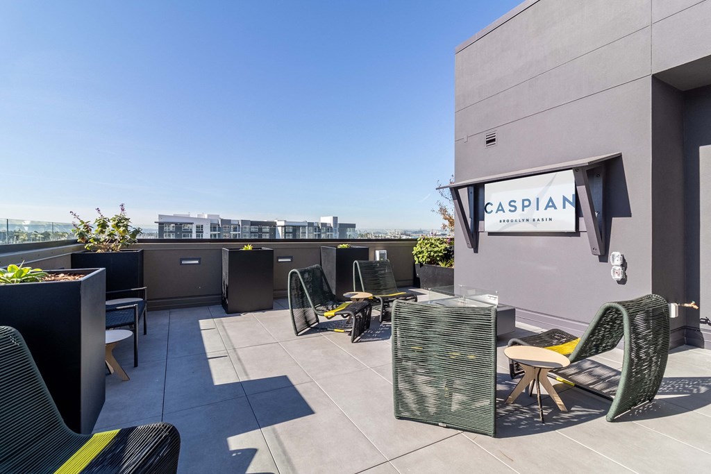 a roof top patio with tables and chairs and a building