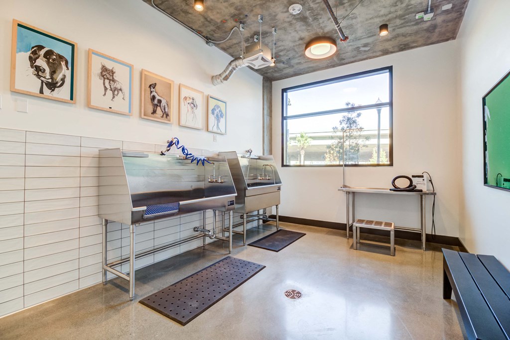 a room with a piano and a window and paintings on the wall