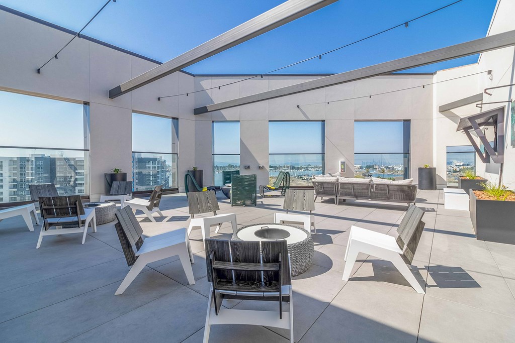 a spacious patio with chairs and tables and views of the city