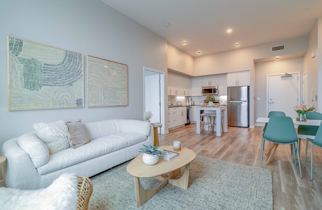 a living room and kitchen with a couch and a table