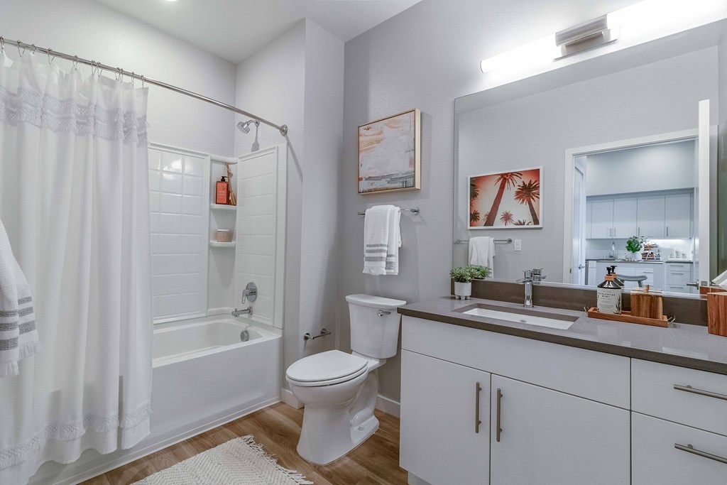 a white bathroom with a shower toilet and sink