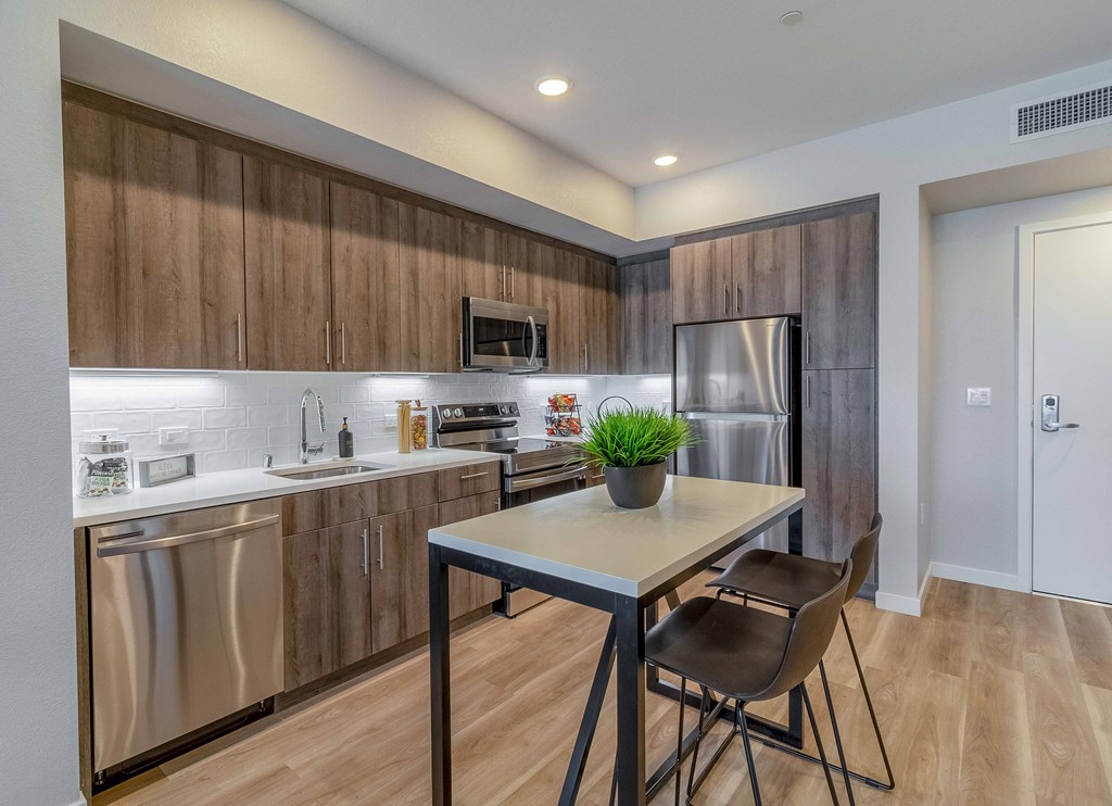 a kitchen with stainless steel appliances and a table with two chairs
