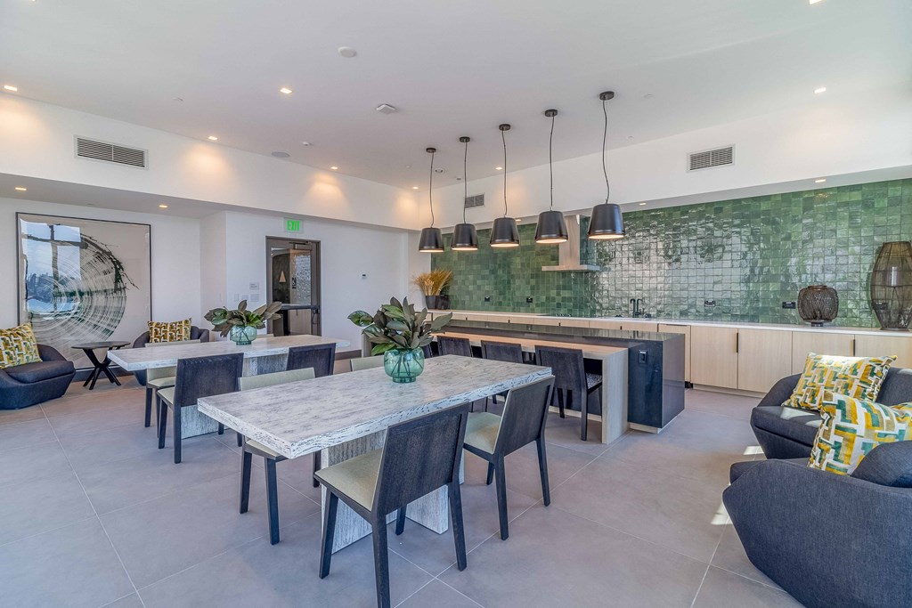 a dining area with a table and chairs and a kitchen