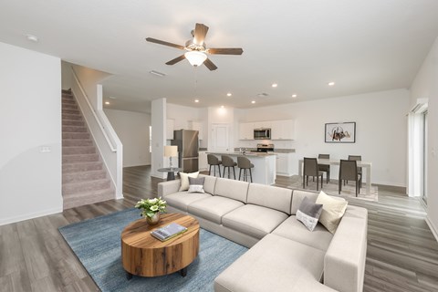 A living room with a white couch and a wooden coffee table.
