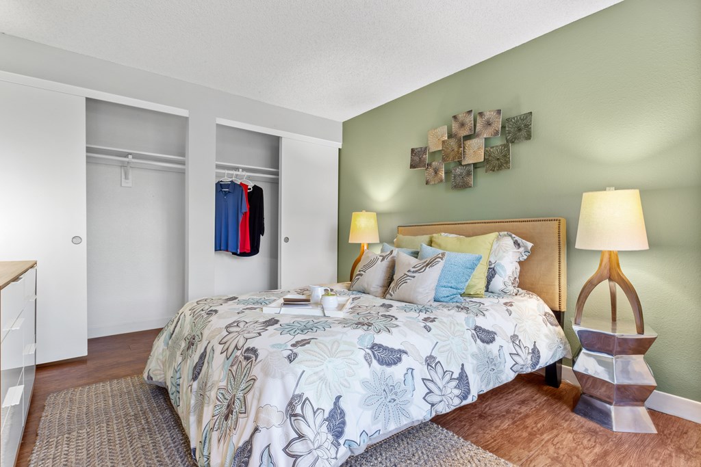A bedroom with a large bed and a lamp on a side table. at Cedar Crest, Beaverton, Oregon