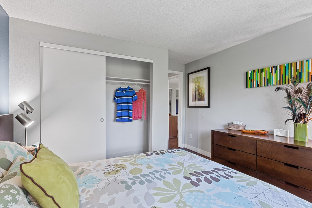 A bedroom with a bed, dresser, and a painting on the wall. at Cedar Crest, Beaverton, 97078
