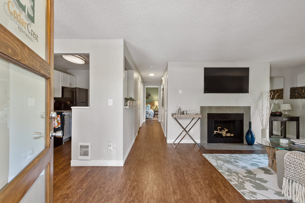 A modern living room with a fireplace and a TV mounted on the wall. at Cedar Crest, Beaverton, Oregon