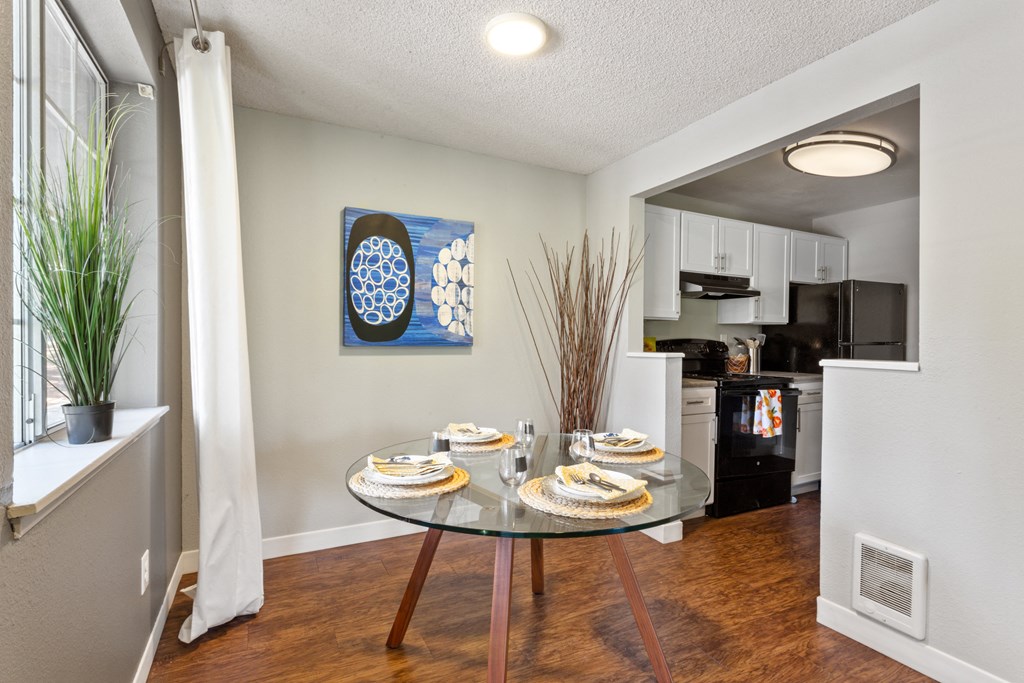 A dining room with a glass table set for two. at Cedar Crest, Beaverton