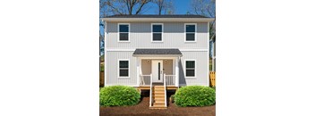 A white house with a grey roof and a front porch.