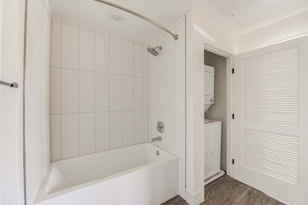 a white bathroom with a tub and a closet