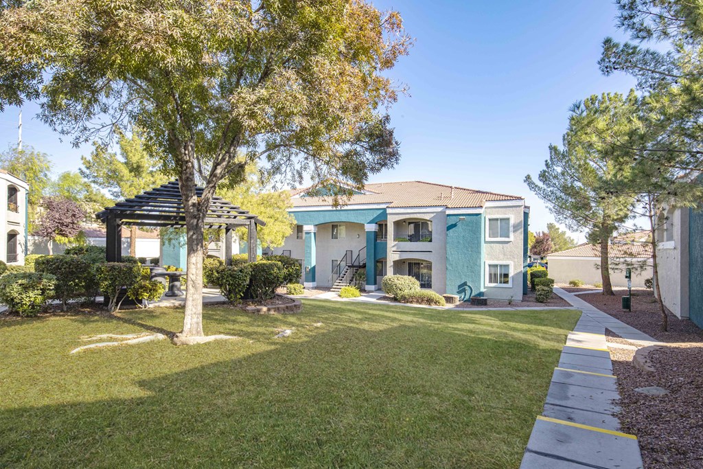 a blue house with a yard and trees and a sidewalk