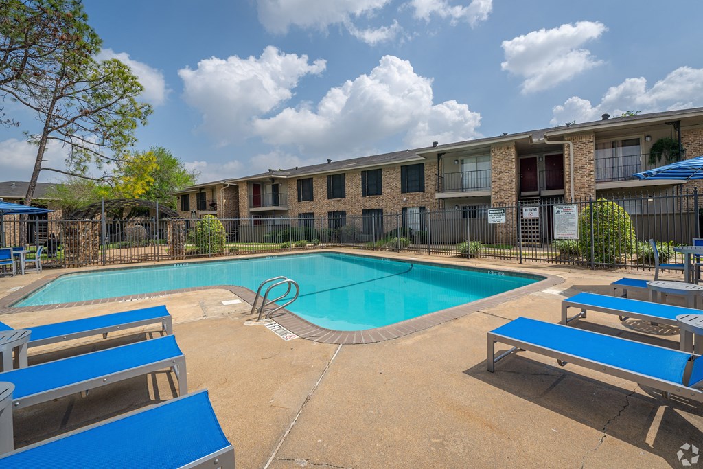 our apartments offer a swimming pool and a patio with blue benches