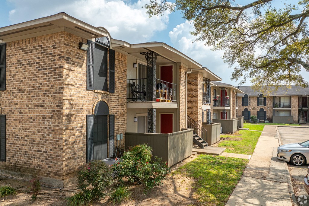 a brick apartment building with a car parked in front of it