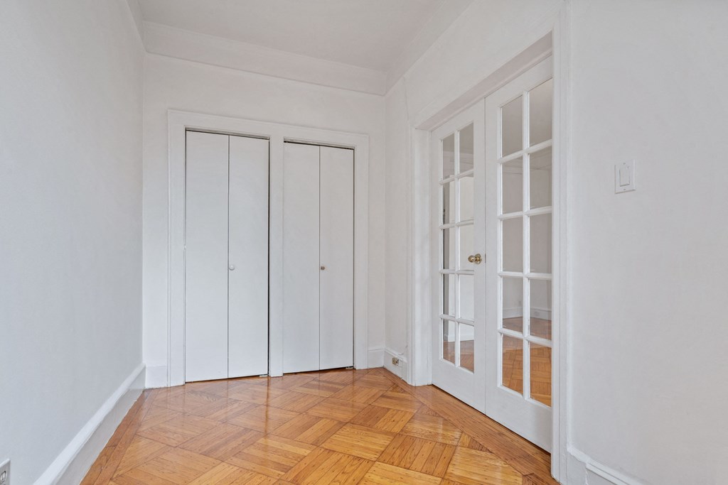 a room with white walls and doors and a wooden floor