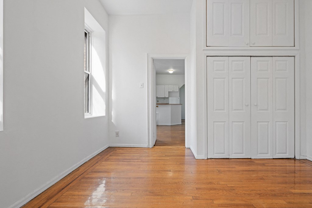 an empty living room with white walls and wood floors