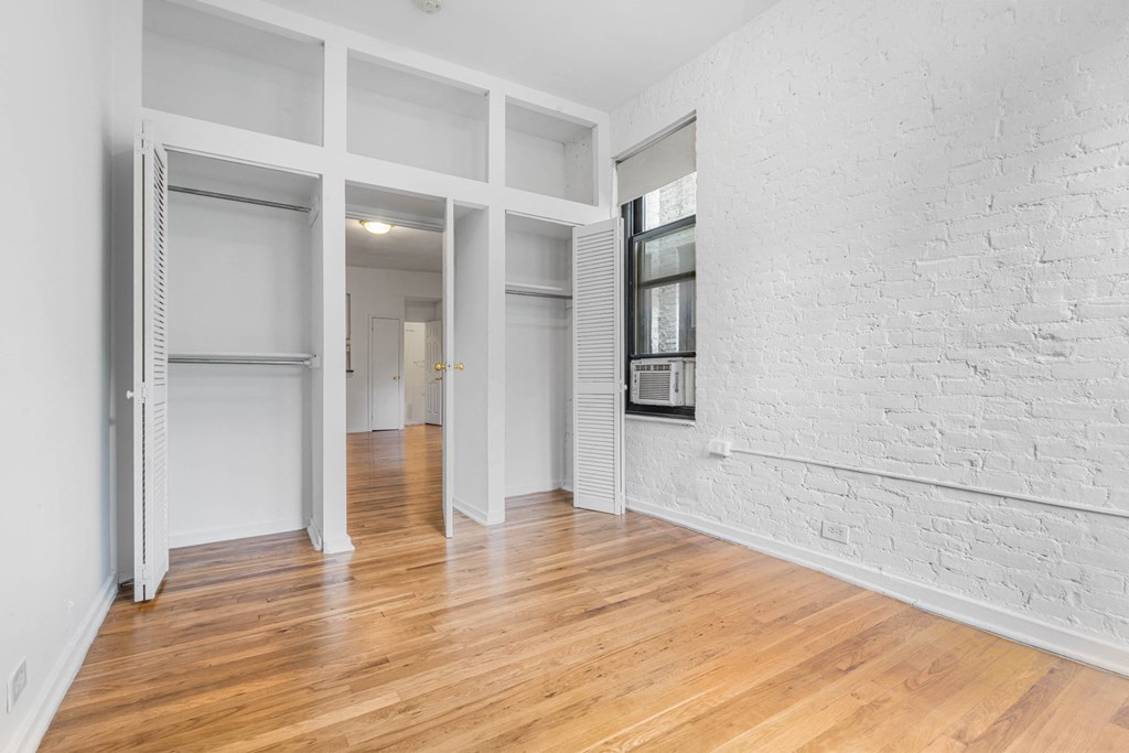 a living room with a white brick wall and wood floors