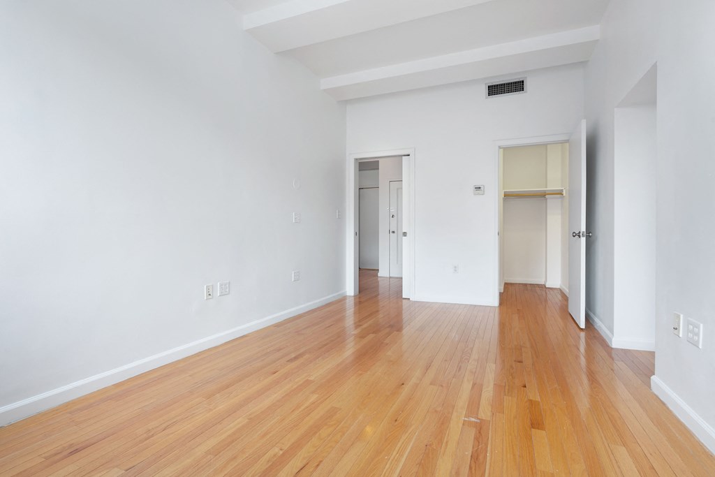 an empty living room with white walls and wooden floors