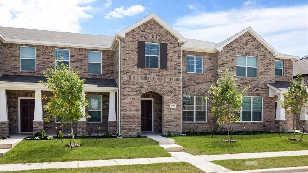 a large brick house with trees in front of it
