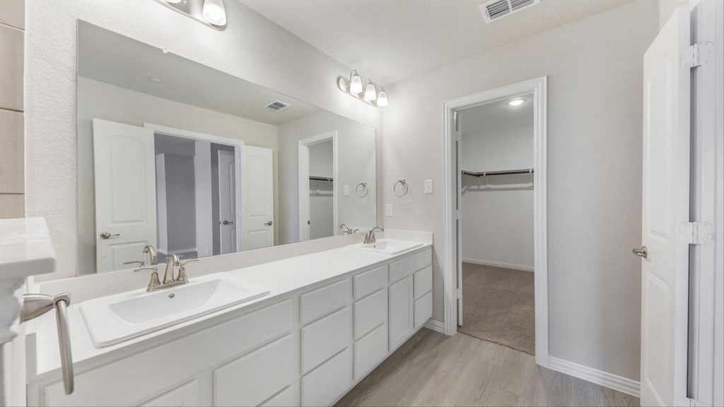 a white bathroom with a large mirror and a white sink
