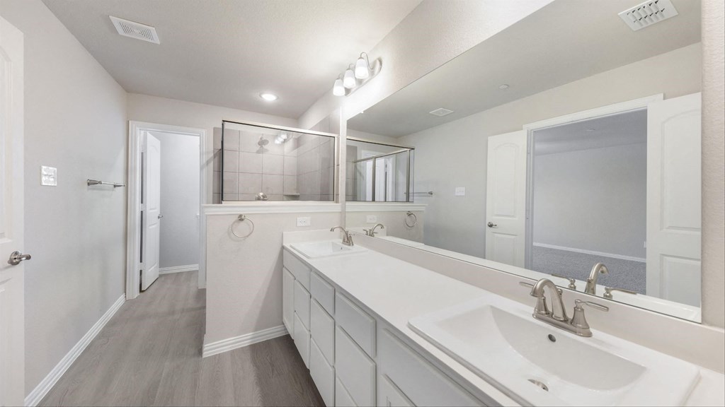 a white bathroom with two sinks and a mirror