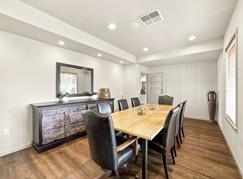 A dining room with a wooden table and chairs.