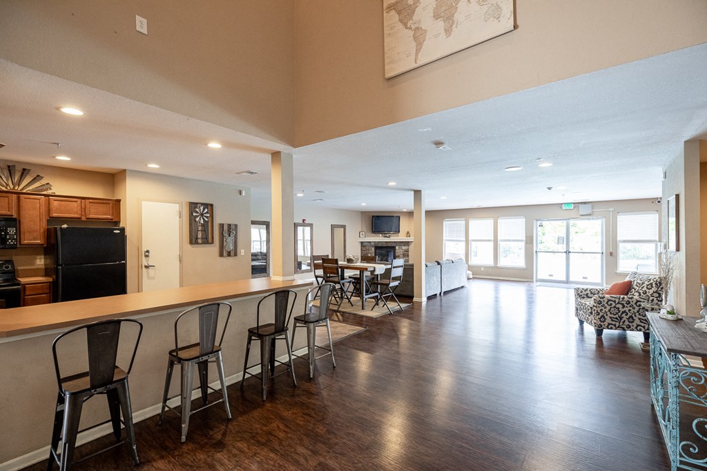 a large living room with a bar and a kitchen