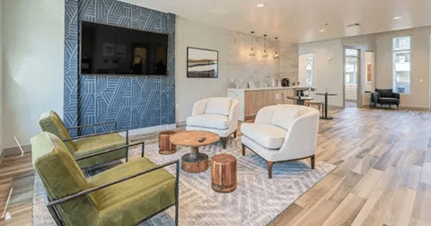 A living room with a television, two chairs, and a coffee table.