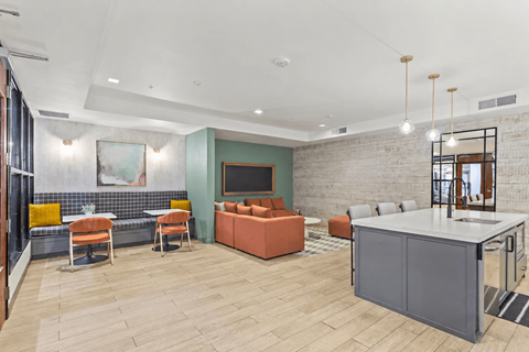 A modern living room with a grey kitchen island and a green accent wall.