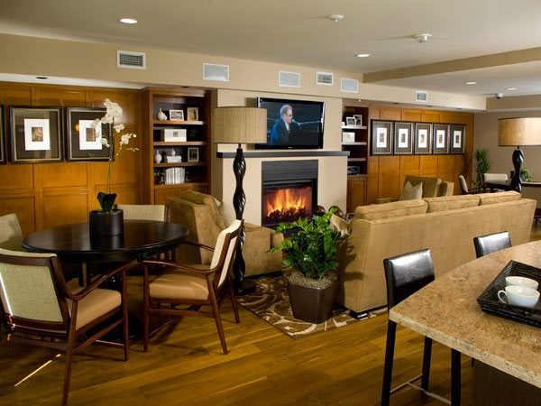 A living room with a fireplace and a television on the wall.