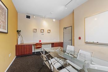 A conference room with a glass table and chairs.